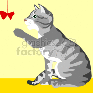 The image is of a cartoon clipart depicting a grey and white striped cat sitting on a yellow surface with its paw lifted as if reaching for a red toy hanging from above. The cat appears to be playful and engaged in a playful activity, showing interest in the dangling toy. The background is a plain light yellow.