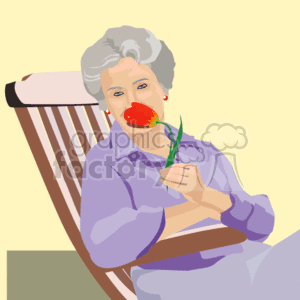 The image depicts a senior citizen woman enjoying the fragrance of a red flower, presumably a rose. The lady is seated comfortably in a chair with a relaxed posture, wearing a light purple shirt. The background is simple with warm tones that complement the subject.