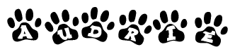 The image shows a row of animal paw prints, each containing a letter. The letters spell out the word Audrie within the paw prints.