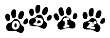 The image shows a series of animal paw prints arranged in a horizontal line. Each paw print contains a letter, and together they spell out the word Odie.