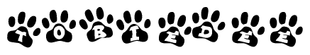 The image shows a series of animal paw prints arranged horizontally. Within each paw print, there's a letter; together they spell Tobiedee