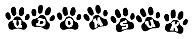 The image shows a row of animal paw prints, each containing a letter. The letters spell out the word Udomsuk within the paw prints.