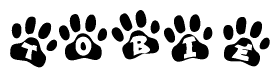 The image shows a row of animal paw prints, each containing a letter. The letters spell out the word Tobie within the paw prints.