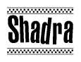 The image is a black and white clipart of the text Shadra in a bold, italicized font. The text is bordered by a dotted line on the top and bottom, and there are checkered flags positioned at both ends of the text, usually associated with racing or finishing lines.